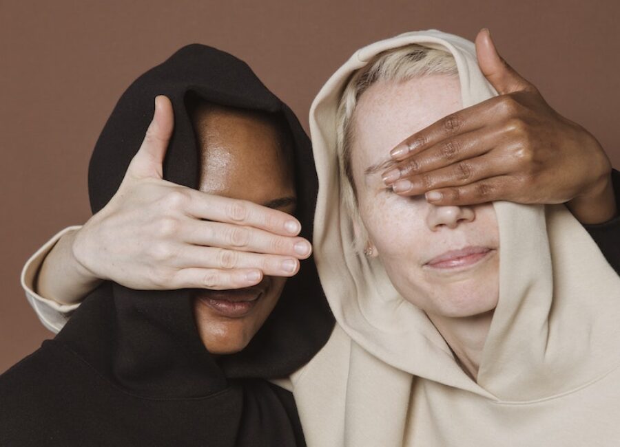 Calm women covering eyes of each other