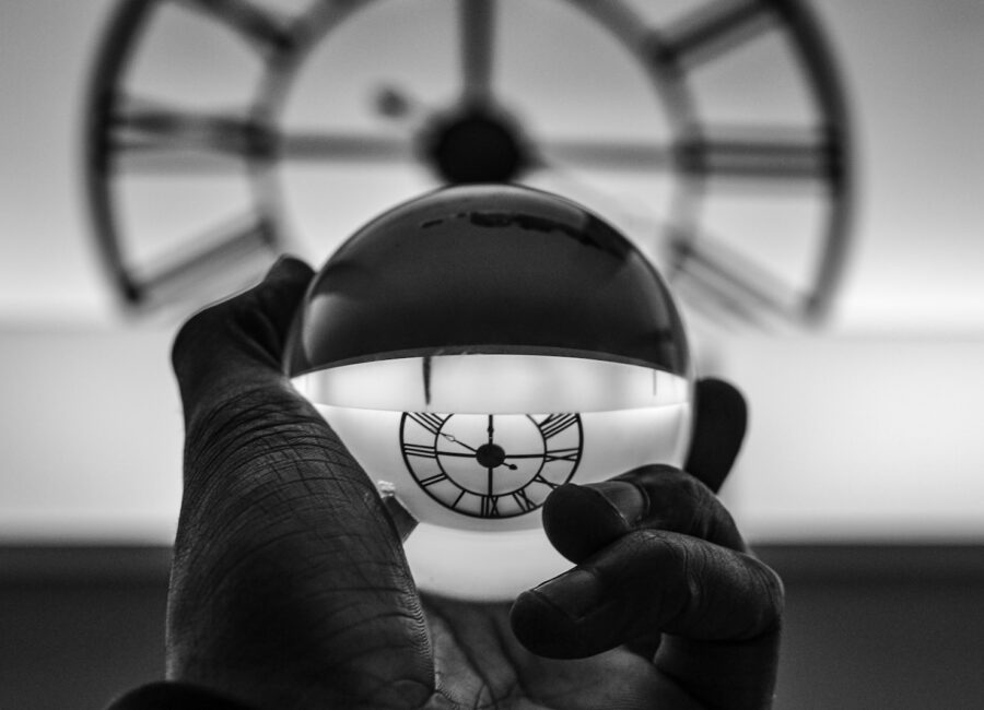 grayscale photography of person holding glass ball